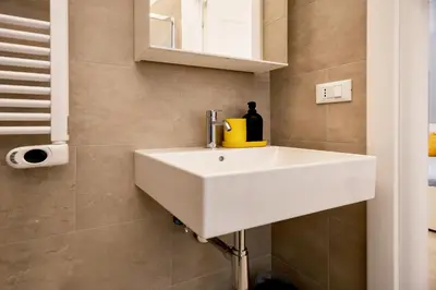 a bathroom with a white sink and a mirror at HC - Chez Le Roi Luxury Apartment in Rome