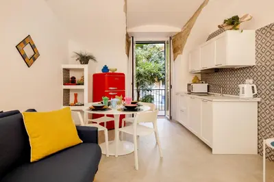 a kitchen and a living room with a table at HC - Chez Le Roi Luxury Apartment in Rome
