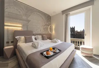 a bedroom with a bed with a tray of food on it at Tritone Luxury Suites Piazza del Popolo in Rome