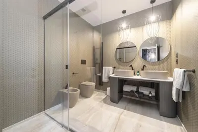 a bathroom with two sinks and a shower at Tritone Luxury Suites Piazza del Popolo in Rome