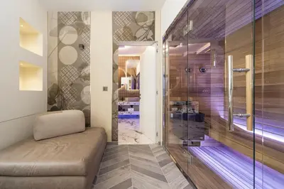 a bathroom with a glass shower with a couch in it at Tritone Luxury Suites Piazza del Popolo in Rome