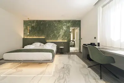 a bedroom with a bed and a desk at Tritone Luxury Suites Piazza del Popolo in Rome