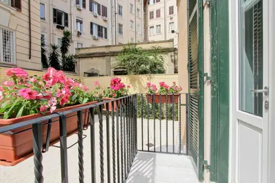 a balcony with pink flowers on a building at Nizza 33 in Rome
