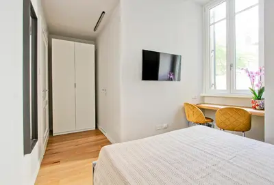 a bedroom with a bed and a desk and a tv at Nizza 33 in Rome