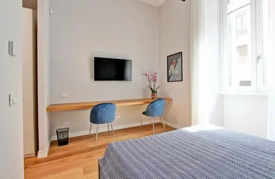 a bedroom with two chairs and a desk with a tv at Nizza 33 in Rome