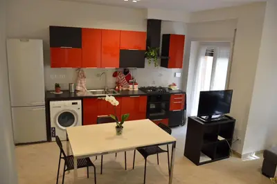 a kitchen with orange cabinets and a table with chairs at Apartment Veio in Rome
