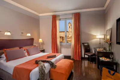 a hotel room with a large bed and a window at The Inn at the Spanish Steps Luxury Collection - The View in Rome