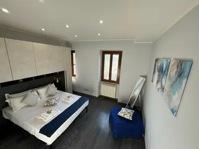 a bedroom with a bed and a painting on the wall at G&G Apartment in Rome Quadraro in Rome