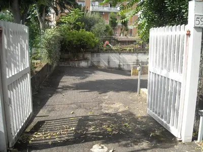 a white fence with a gate in front of a driveway at StudioFlat Battistini in Rome