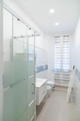 a white bathroom with a sink and a toilet at When in Rome in Rome