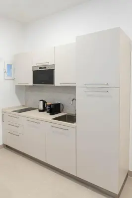 a white kitchen with a sink and a refrigerator at When in Rome in Rome