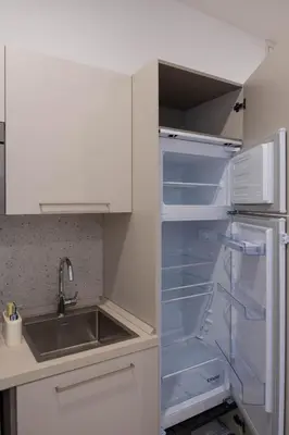 an empty refrigerator with its door open in a kitchen at When in Rome in Rome