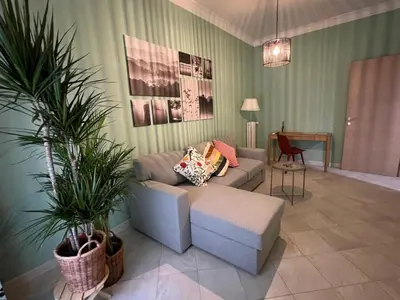 a living room with a couch and potted plants at Maison Roberto in Rome