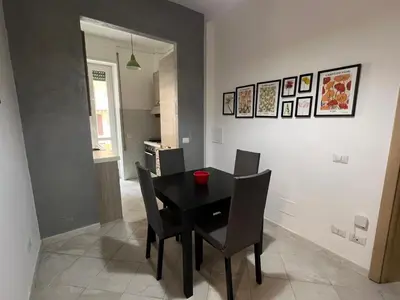 a dining room with a black table and chairs at Maison Roberto in Rome
