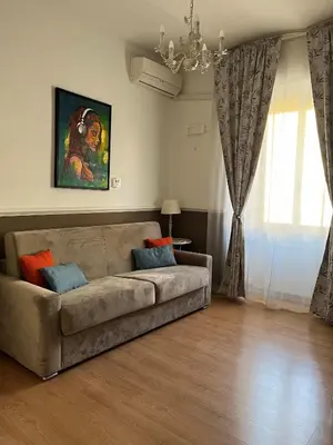 a living room with a couch and a chandelier at Veniero Apartment in Rome