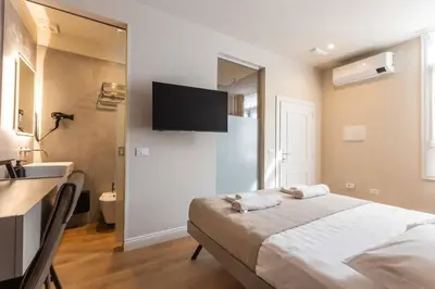 a bedroom with a bed with a television on the wall at LUMINA3 Luxury Room ROME in Rome