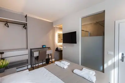 a bedroom with a white bed and a desk at LUMINA3 Luxury Room ROME in Rome