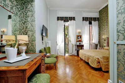 a bedroom with a bed and a desk in a room at Domus Monamì Luxury Suites in Rome