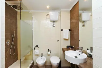a bathroom with a sink and a toilet and a shower at Domus Monamì Luxury Suites in Rome