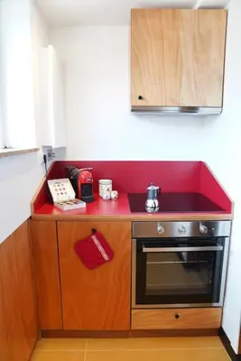 a small kitchen with a red counter top at Villa Bonelli Penthouse in Rome