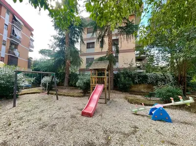 a playground in front of a building with a red slide at Villa Bonelli Penthouse in Rome