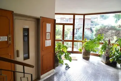 an empty hallway with potted plants and an open door at Villa Bonelli Penthouse in Rome
