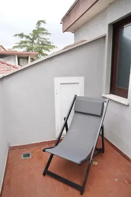 a black chair sitting on a porch next to a building at Villa Bonelli Penthouse in Rome