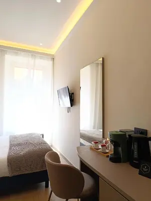 a bedroom with a bed and a desk with a mirror at HoneyComb GuestHouse in Rome