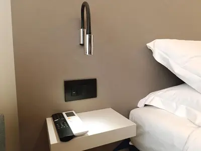 a phone on a table next to a bed at HoneyComb GuestHouse in Rome
