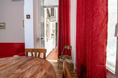 a room with a table and a red curtain at House Serena in Rome