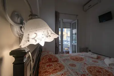 a bedroom with a bed with a lamp on it at House Serena in Rome