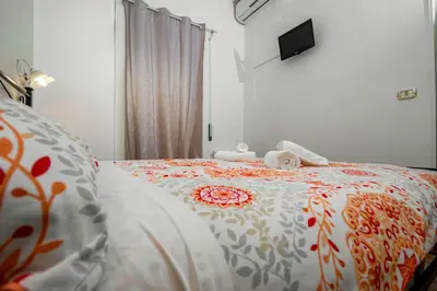 a bedroom with a bed with an orange and white comforter at House Serena in Rome