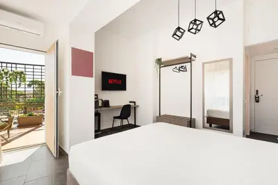 a bedroom with a white bed and a desk at Adelante Rooms San Giovanni in Rome