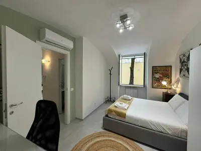 a bedroom with a bed and a table and a window at Quiet Corner in the Eternal City in Rome