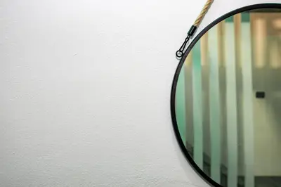 a mirror hanging on a wall with a racket at Casa Cristallo Relax e Spa in Rome