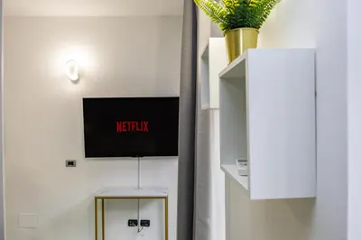 a living room with a tv on a wall at Casa Cristallo Relax e Spa in Rome
