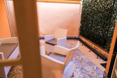 a balcony with two white chairs and a table at Stefy's House in Rome