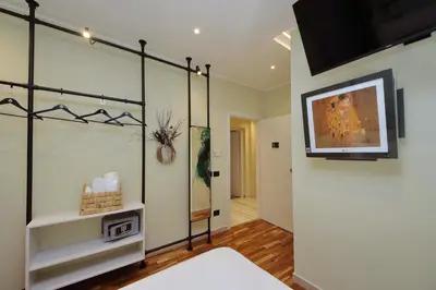 a room with a bed and a tv on a wall at San Pietro Luxury Rooms in Rome