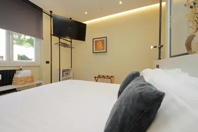 a bedroom with a large white bed and a window at San Pietro Luxury Rooms in Rome