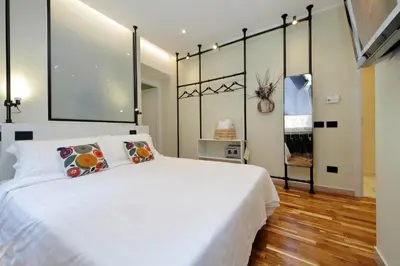 a bedroom with a large white bed with two pillows at San Pietro Luxury Rooms in Rome