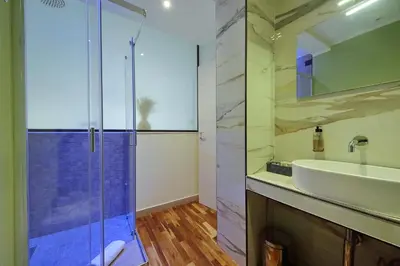 a bathroom with a glass shower and a sink at San Pietro Luxury Rooms in Rome