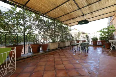 a patio with tables and chairs and potted plants at Spagna Prestige Apartment in Rome