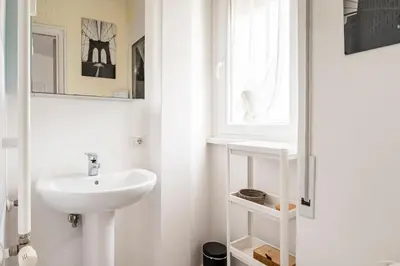 a white bathroom with a sink and a window at Vatican Penthouse 1 by Almond Tree in Rome