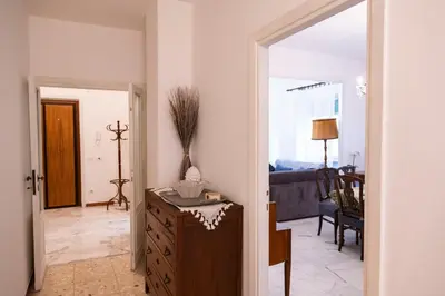 a living room with a dresser and a room with a couch at archi gianicolensi apartment in Rome