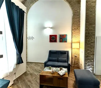 a living room with a blue chair and a table at Casa Valenziani in Rome