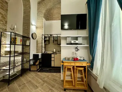 a room with a kitchen with a table and a counter at Casa Valenziani in Rome