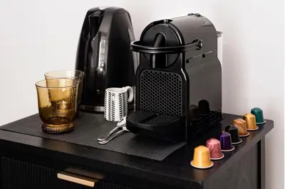 a coffee maker on a black counter with a drink at The Rubens Collection in Rome