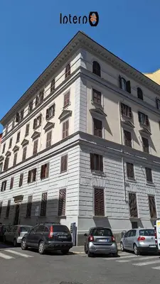 a large white building with cars parked in front of it at Interno 16 central and cosy in Rome