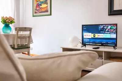 a living room with a television on a table with a chair at Interno 16 central and cosy in Rome