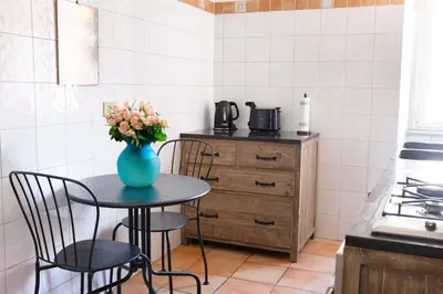 a kitchen with a table with a vase of flowers on it at Interno 16 central and cosy in Rome